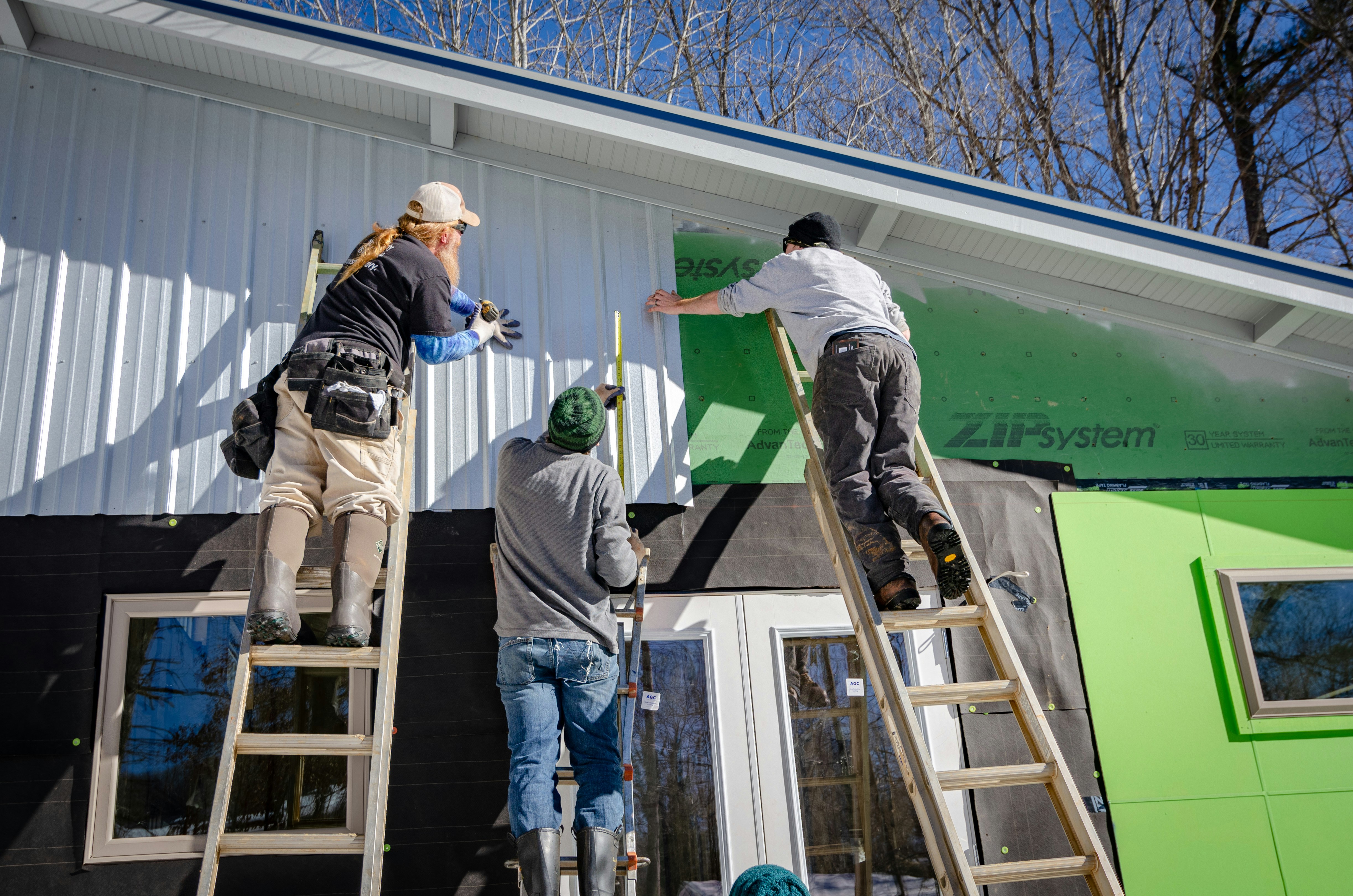 Professional contractors working on home exterior siding installation